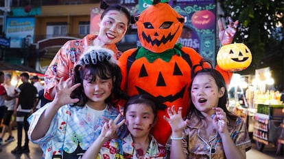 Una familia en la calle disfrazados de Halloween.