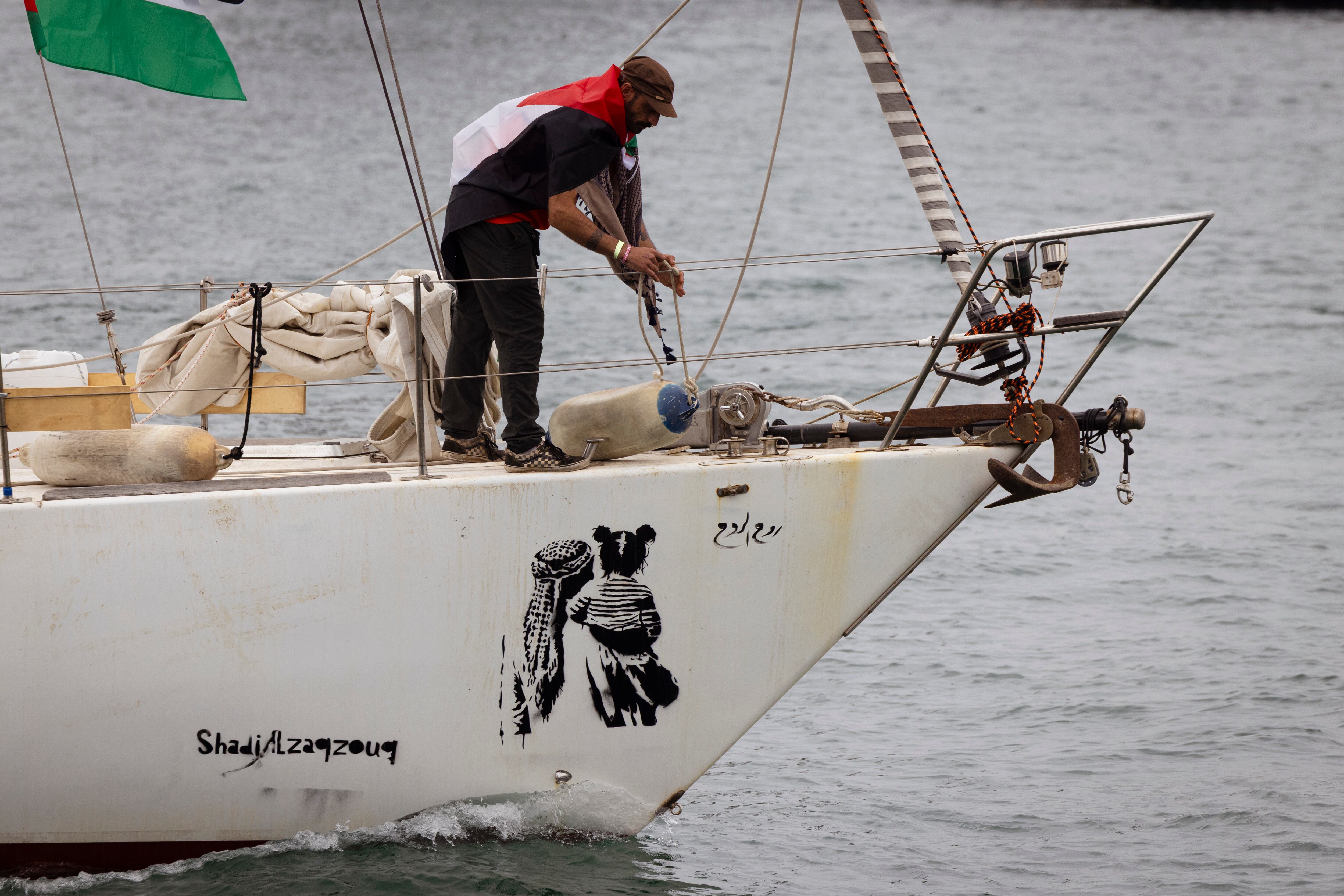 Un miembro de la Global Sumud Flotilla preparaba uno de los barcos en el puerto de Barcelona, este domingo.