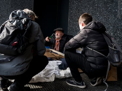 Dos voluntarios de Arrels visitando a una persona sin hogar