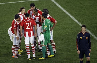 Fernando Torres se encamina al vestuario tras el final de la primera parte, al tiempo que los jugadores paraguayos hablan entre ellos.