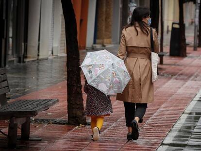 Una madre pasea con su niña por la calle Asunción de Sevilla. 