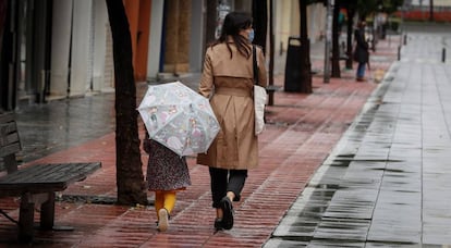 Una madre pasea con su niña por la calle Asunción de Sevilla. 