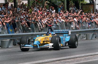Fernando Alonso conduce por la Castellana aclamado por los aficionados.