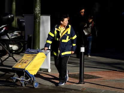 Una cartera de Correos con el carrito en la zona de Arg&uuml;elles, Madrid. 