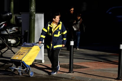 Una cartera de Correos con el carrito en la zona de Arg&uuml;elles, Madrid. 