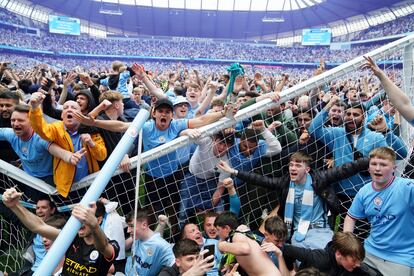 Aficionados del Manchester City rompen una de las porterías tras invadir el campo del Etihad, el domingo.