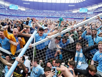 Aficionados del Manchester City rompen una de las porterías tras invadir el campo del Etihad, el domingo.