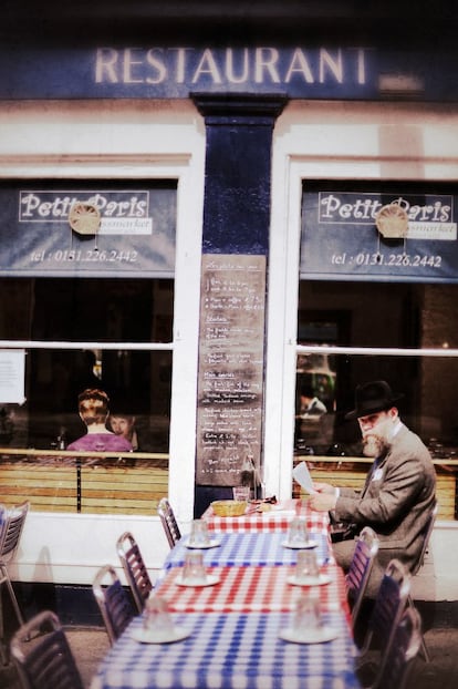 Un hombre lee el periódico en un restaurante en Grassmarket, la zona baja del corazón de la ciudad vieja.