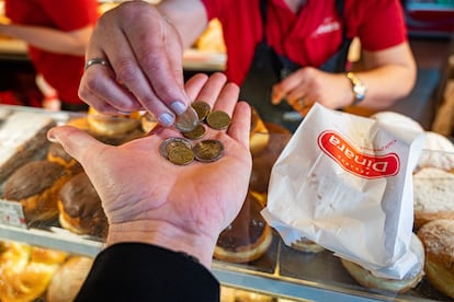 Un cliente recibe el cambio de su compra en una panadería en Zagreb, el lunes.