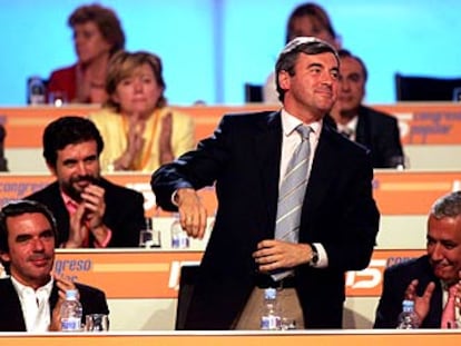Ángel Acebes, entre Aznar y Arenas, es aplaudido por los miembros de la ejecutiva.