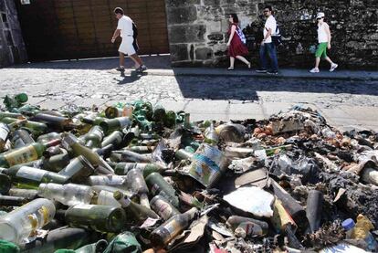 Basura desperdigada por la quema de un contenedor en la calle Castiñeira, en el borde del casco histórico de Santiago.
