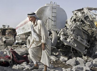 Un vecino de Jazna, cerca de Mosul, pasa junto a uno de los camiones bomba que explotaron ayer.