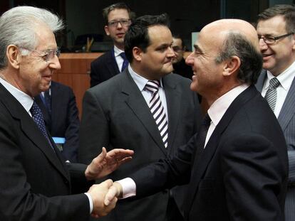 Luis de Guindos, ministro de Economía español, saluda al Primer Ministro de Italia, Mario Monti, ayer en Bruselas.