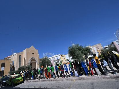 Los migrantes esperaban en fila para ser trasladados a otros lugares desde la isla de Lampedusa, en el sur de Italia, el viernes.