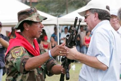 Ramón Isaza (izquierda) entrega su arma al alto comisionado para la Paz, Luis Carlos Restrepo.