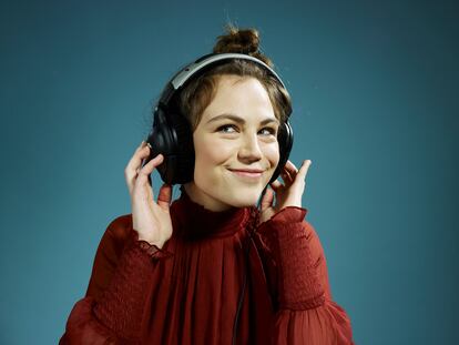 A young hip woman wearing headphones and smiling