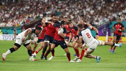 Piers Francis, de Inglaterra, defiende el balón ante Cam Dolan, de Estados Unidos.