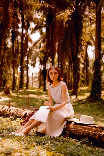 Top de cuadros, falda midi y sombrero. Tres prendas que podemos encontrar en cualquier tienda para copiarle el lookazo a Audrey Hepburn. La imagen es de 1955.