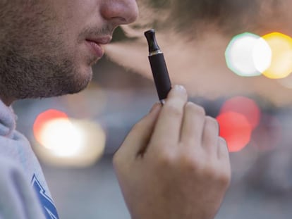 Un hombre fuma un cigarrillo electr&oacute;nico en una calle de Barcelona.