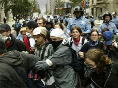 Un grupo de manifestantes de los movimientos contra la globalización corre ante la policía en las calles de Washington.
