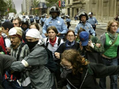 Un grupo de manifestantes de los movimientos contra la globalización corre ante la policía en las calles de Washington.