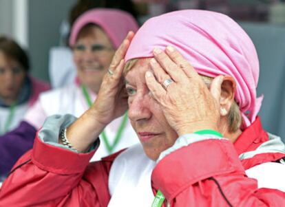 Una mujer se coloca un pañuelo en la cabeza para formar parte del lazo humano de este color que formaron hoy en Bilbao numerosas personas dentro de las actividades que la Asociación contra el Cáncer ha organizado con motivo del Día contra el Cáncer de Mama.