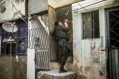 Policial do CORE (Coordenadoria de Recursos Especiais da Polícia Civil) revista um casa do Complexo da Maré, no Rio de Janeiro, em busca de criminosos. A ocupação faz parte do processo de instalação das Unidades de Polícia Pacificadora (UPP) no local.