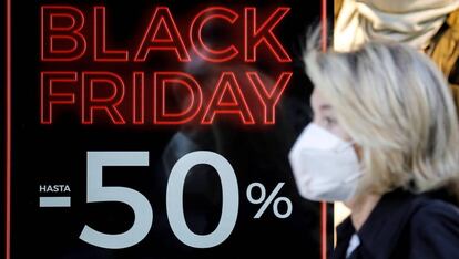 Una persona pasa ante un escaparate con promociones del Black Friday