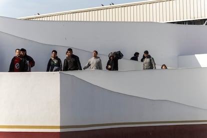 Personas que han sido deportadas, cruzan el puente migratorio en Tijuana la mañana de este lunes. 