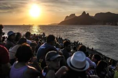 Un grupo de personas observa la puesta del sol en la piedra de Arpoador en Río de Janeiro (Brasil). La piedra de Arpoador, que divide las playas de Copacabana e Ipanema en Río de Janeiro, es el lugar más concurrido de esta ciudad brasileña para divisar la puesta de sol.