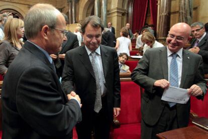 El presidente catalán, José Montilla (izquierda), da la mano al líder de CiU, Artur Mas, ayer en el Parlamento catalán.
