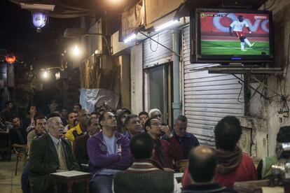 Un grupo de aficionados egipcios sigue a través de la televisión de un establecimiento de El Cairo el partido entre Egipto y Ghana, en el que su selección quedó eliminada.