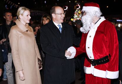 Los príncipes de Mónaco, Alberto y Charlene, saludan a Papá Noel durante la apertura del mercadillo de Navidad que se celebra cada año en el Principado.