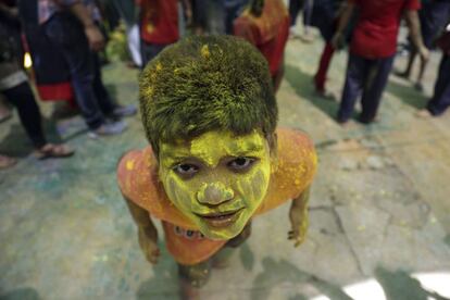 Un niño discapacitado indio cubierto de polvos de colores en Thane (India).