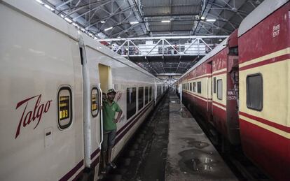 Dos personas esperan en uno de los vagones de un tren de Talgo a su llegada a la estación central de Bombay.