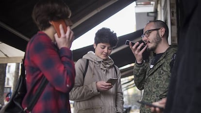 Un grupo de j&oacute;venes usando sus tel&eacute;fonos m&oacute;viles.
 