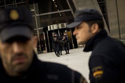 Varios polícias extraen a uno de los manifestantes que entró en la sede de Bankia.