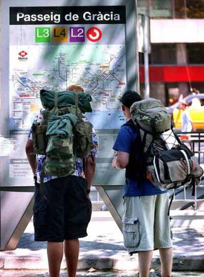 Unos turistas mirando un plano del metro de Barcelona.