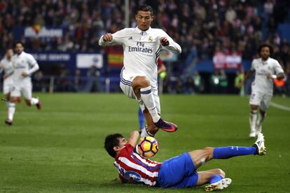 Cristiano Ronaldo del Real Madrid salta sobre Montenegrin del Atlético.