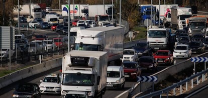 Camiones y otros vehículos en una autopista a su paso por Madrid.