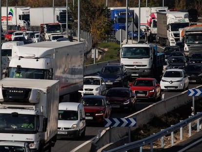 Camiones y otros vehículos en una autopista a su paso por Madrid.