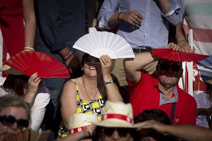 Debido al fuerte sol, los asistentes al mitin de Susana Díaz se cubría la cara con abanicos ofrecidos por la organización.