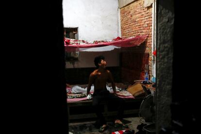 Worker Shi Shenwei yawns after waking up in a colleague's room in an old farm house in the village of Huangshan, near Quanzhou, Fujian Province, China, September 28, 2016. Shi had to vacate his room after heavy rain leaked through the roof and wet his mattress. REUTERS/Thomas Peter       SEARCH "BRICK CARRIER" FOR THIS STORY. SEARCH "WIDER IMAGE" FOR ALL STORIES.     TPX IMAGES OF THE DAY