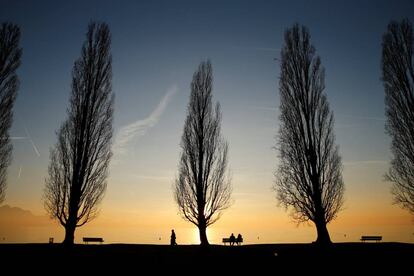 Personas sentadas en un banco en una tarde de otoño, en un parque cerca del lago Lemán (Suiza).