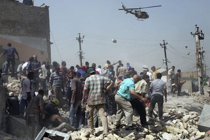 Equipos de rescate y vecinos buscan a supervivientes entre los escombros de uno de los edificios destruidos por los atentados de Bagdad.