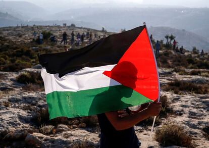 Un joven palestino agita una bandera durante una manifestación en la aldea de Ras Karkar al oeste de Ramallah en la ocupada Cisjordania.