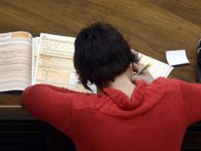 Una mujer rellena los documentos de la Declaración de la Renta 2012 en la sede de la Delegación de la Agencia Tributaria de Valladolid. EFE/Archivo
