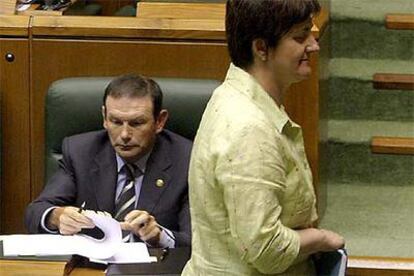 La portavoz de EHAK, Nekane Erauskin, pasa junto a Juan José Ibarretxe en el pleno de ayer.