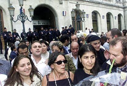 Tumulto ante el Ayuntamiento de Valence (Francia). A la derecha, Malika con un ramo de flores. PLANO GENERAL - ESCENA