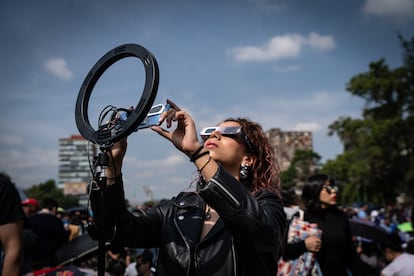 Una mujer observa el eclipse de sol anular que se vio de forma parcial en Ciudad de México el 14 de octubre De 2023.